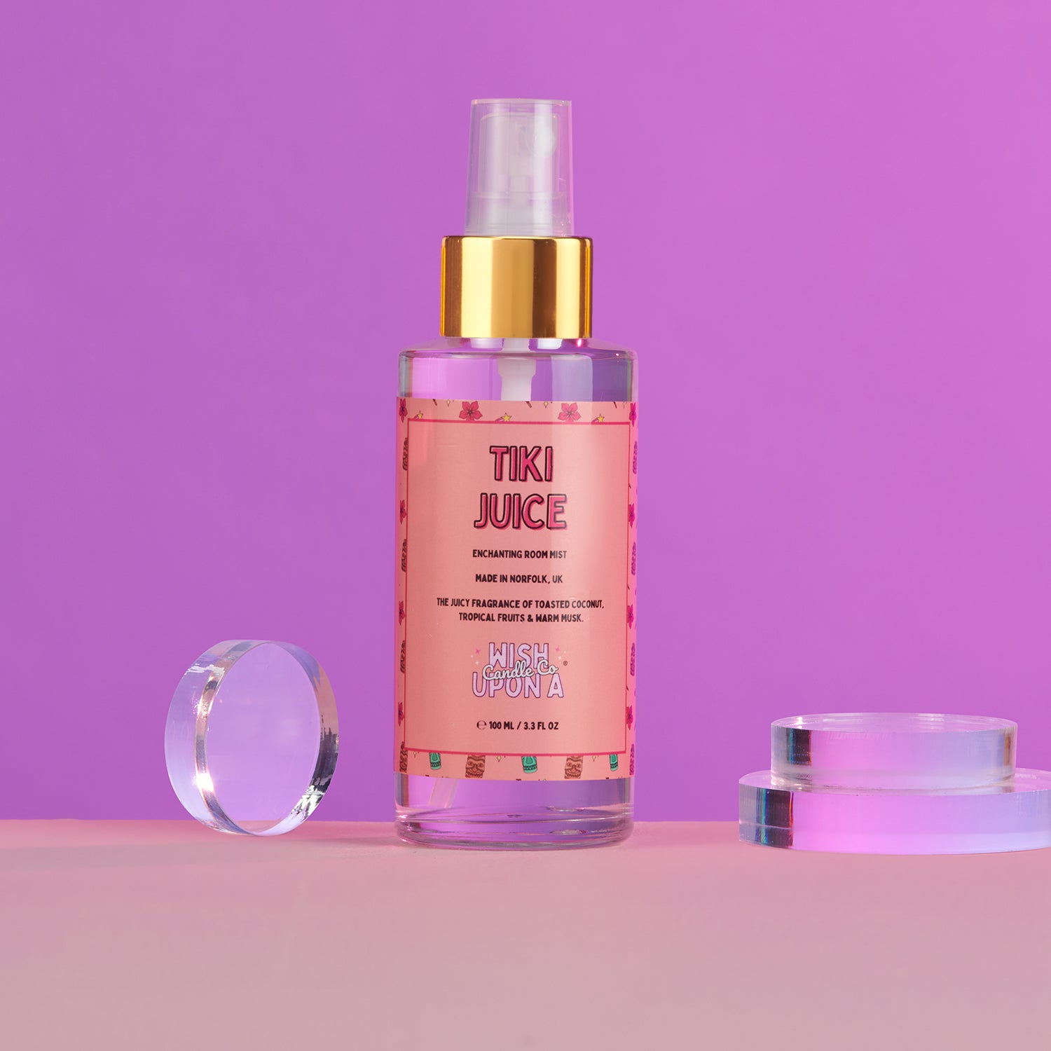 Tiki Juice perfume bottle with a gold cap on a pink and purple gradient background