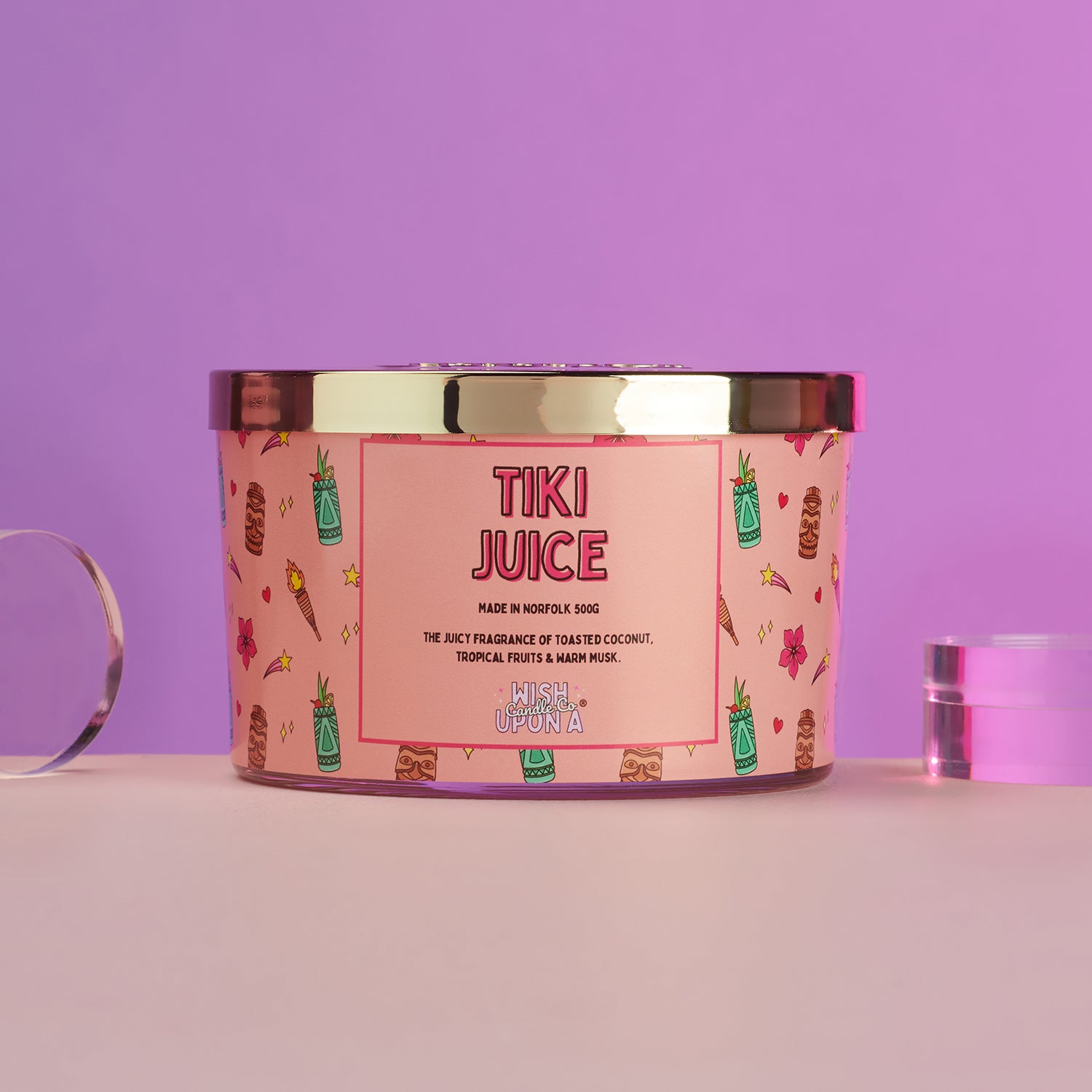 Tiki Juice candle with decorative label on a pink background
